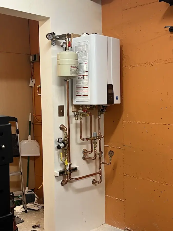 Plumbing technician inspecting water heater connections in East Hanover